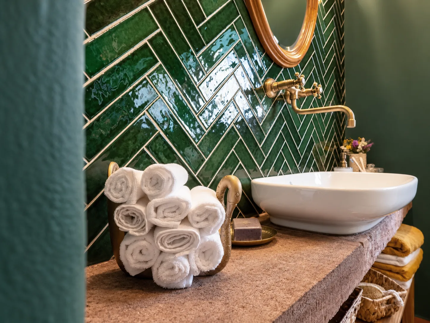 Detail zeleného obkladu, mosazné baterie a umyvadla v přízemní koupelně