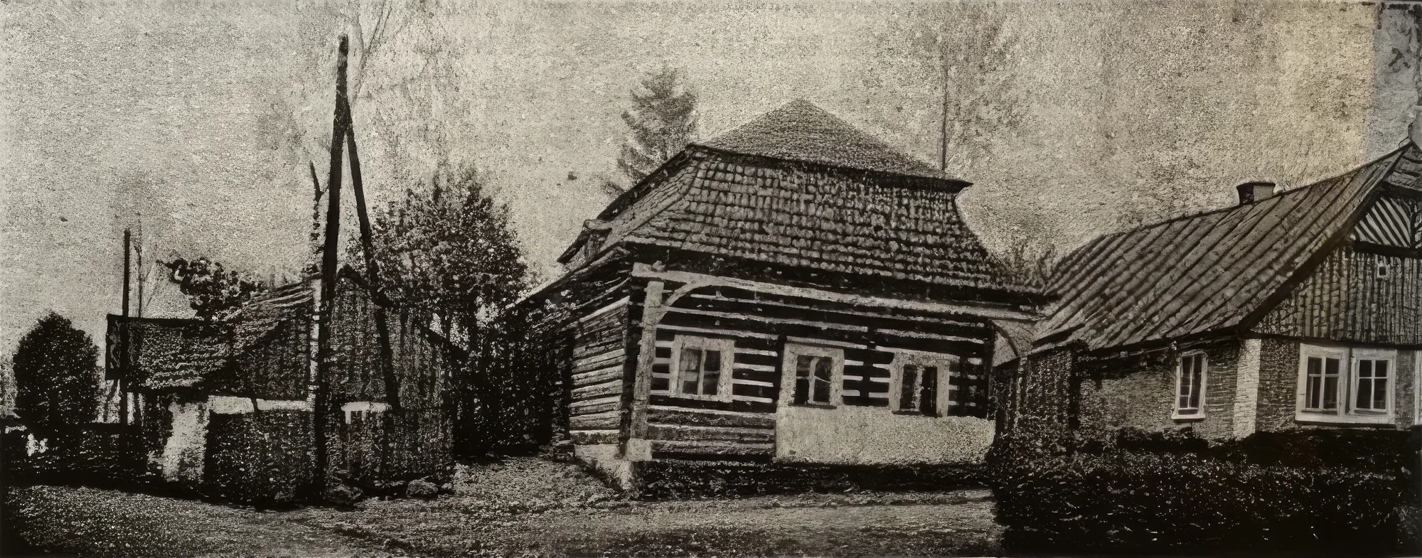 Historická černobílá fotografie roubeného domu s podsíní
