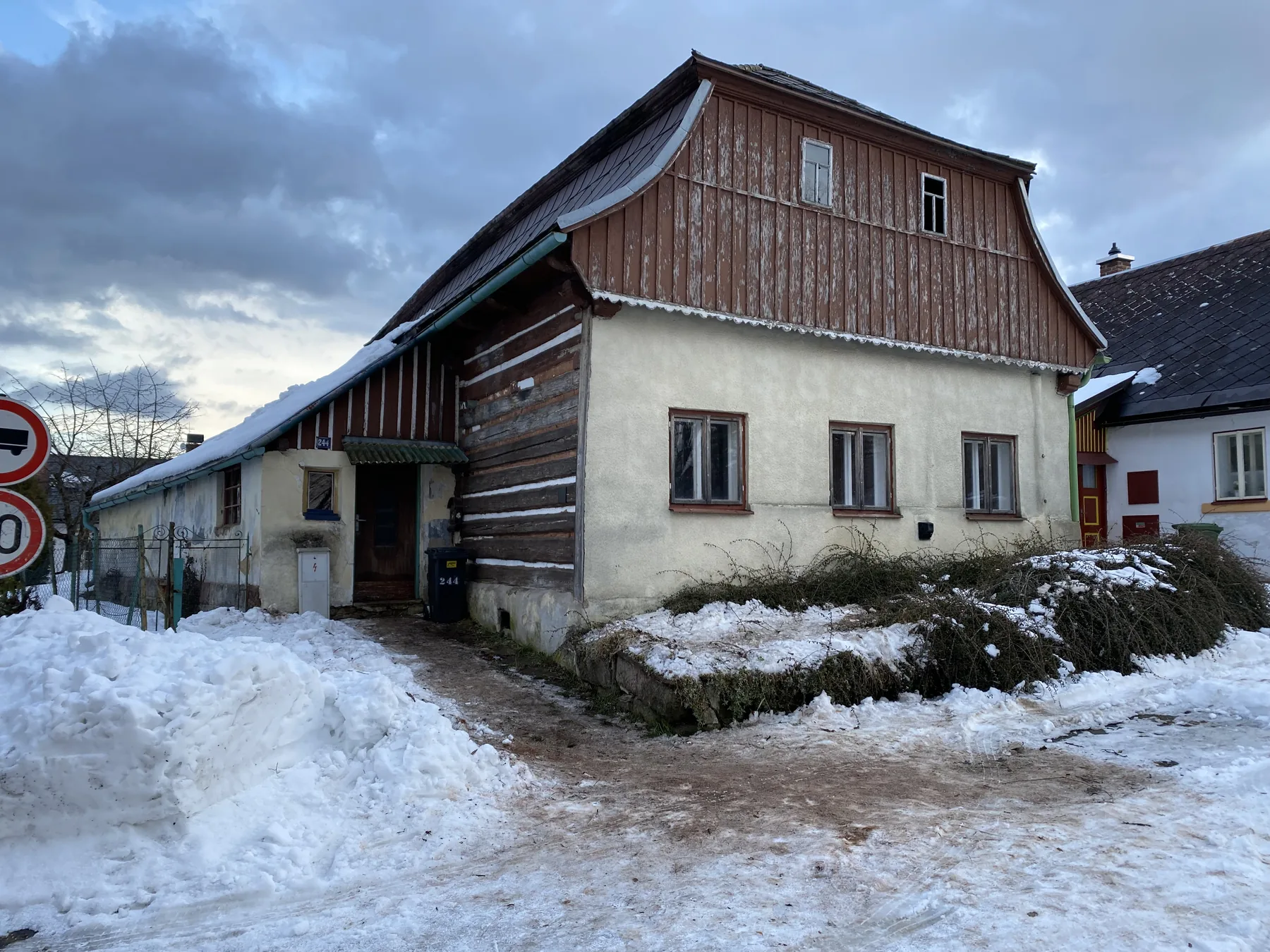 Dům před rekonstrukcí v zimě, s přestavěným patrem a bez podsíně